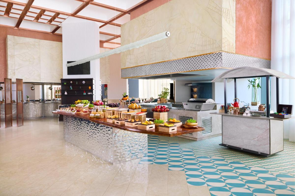 a kitchen with a counter with food on it at Novotel New Delhi City Centre in New Delhi a kitchen with a counter with food on it at Novotel New Delhi City Centre in New Delhi