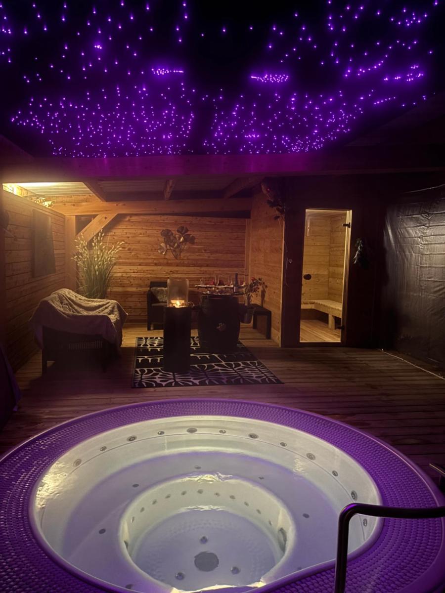 une baignoire dans une pièce éclairée de lumières violettes dans l'établissement Résidence Côté Chalet, à Thonon-les-Bains