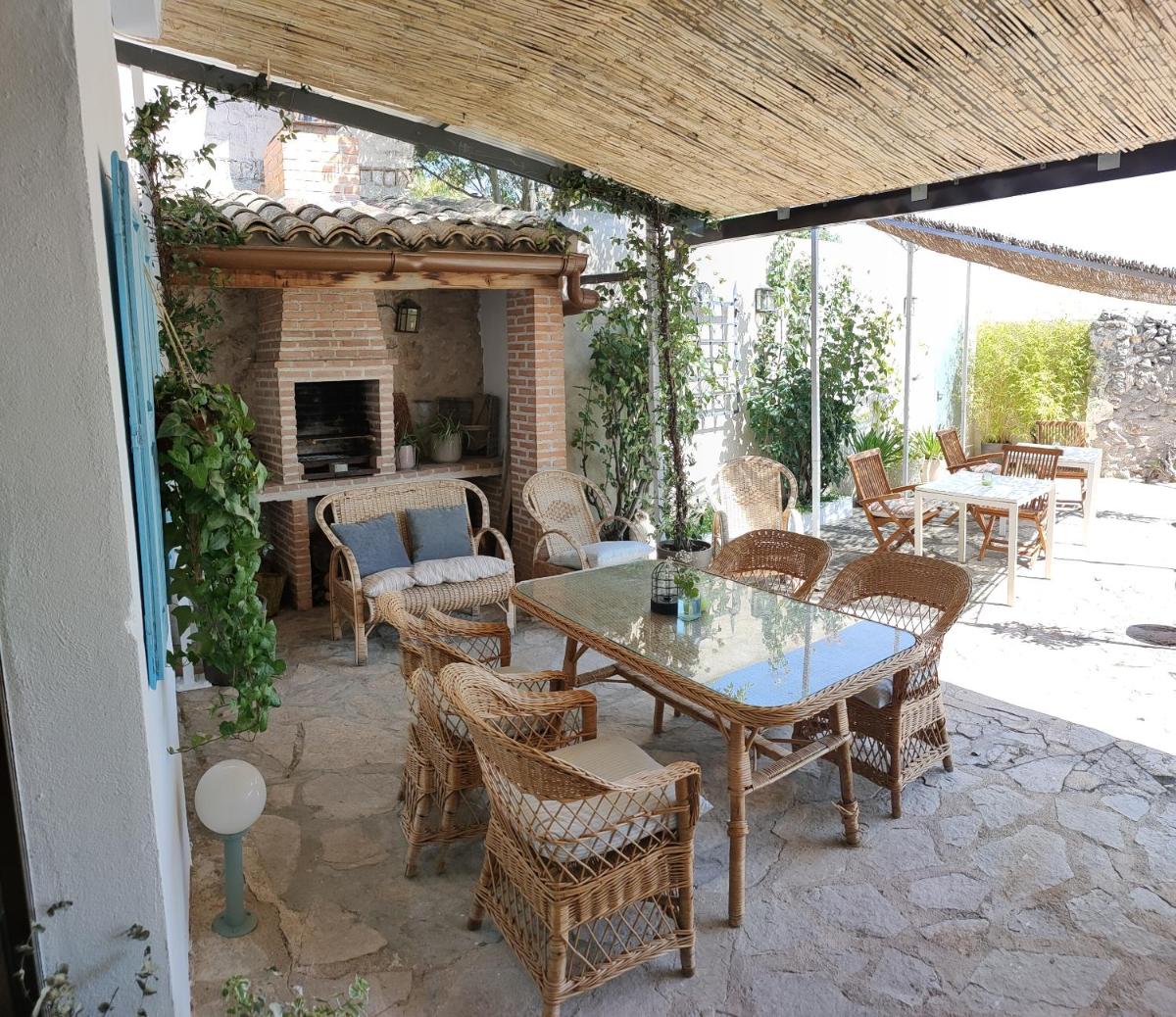 Un patio con mesa y sillas y una chimenea. en Hotel La Casa del Canónigo, en Caracenilla
