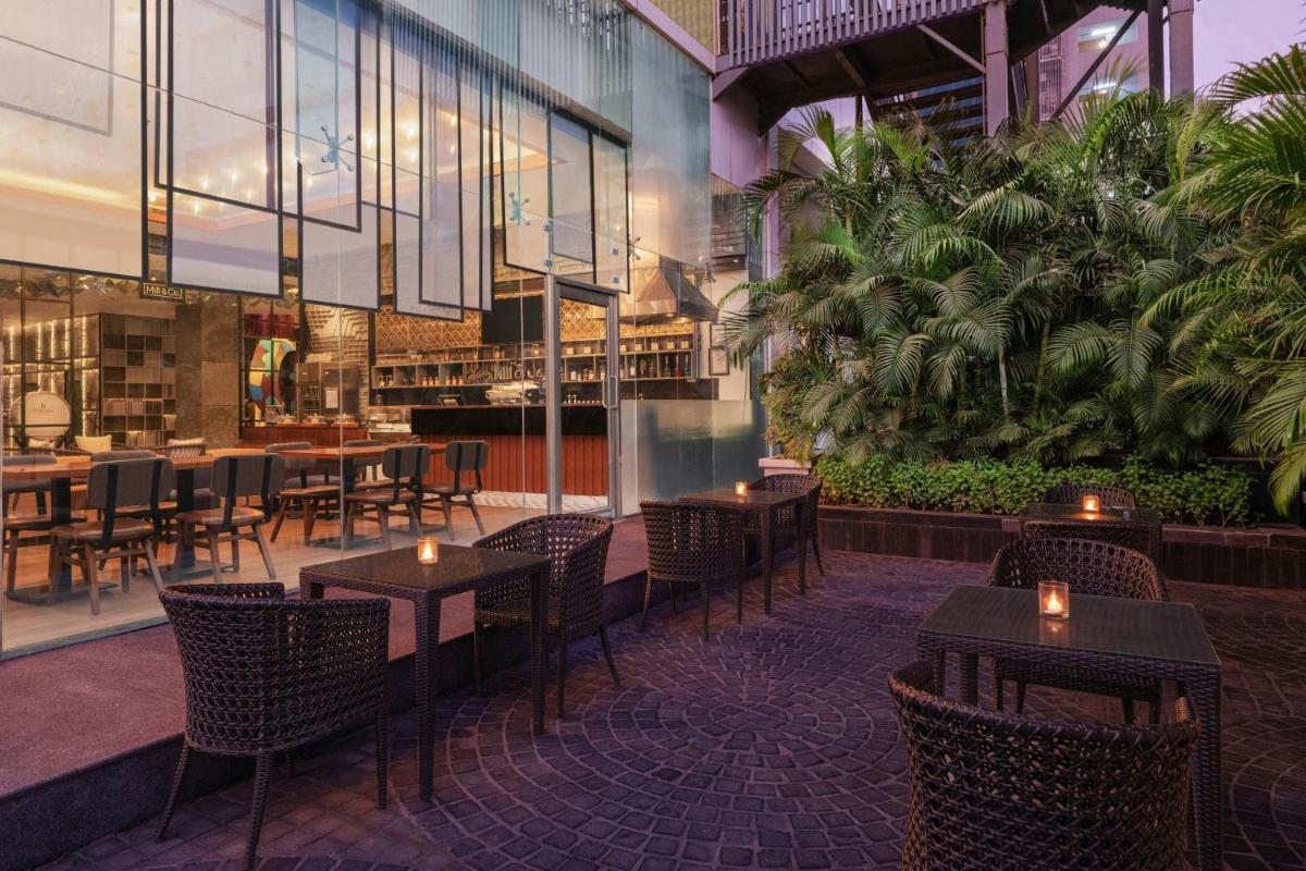 a restaurant with tables and chairs in a building at Renaissance Ahmedabad Hotel in Ahmedabad