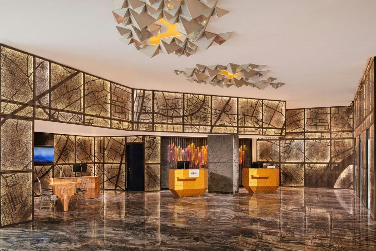 a lobby with a gold and black wall at Renaissance Ahmedabad Hotel in Ahmedabad