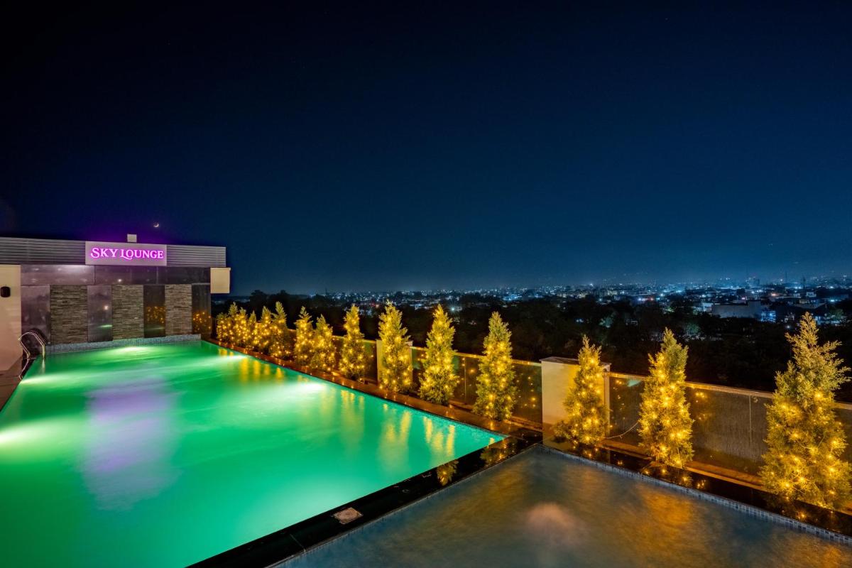 a swimming pool at night with trees and lights at Regenta Dehradun by Royal Orchid Hotels Limited in Dehradun