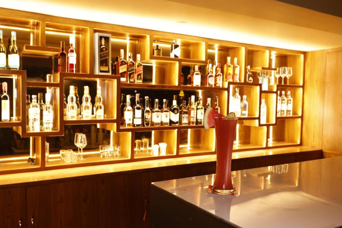 a bar with a lot of bottles of alcohol at Regenta Dehradun by Royal Orchid Hotels Limited in Dehradun
