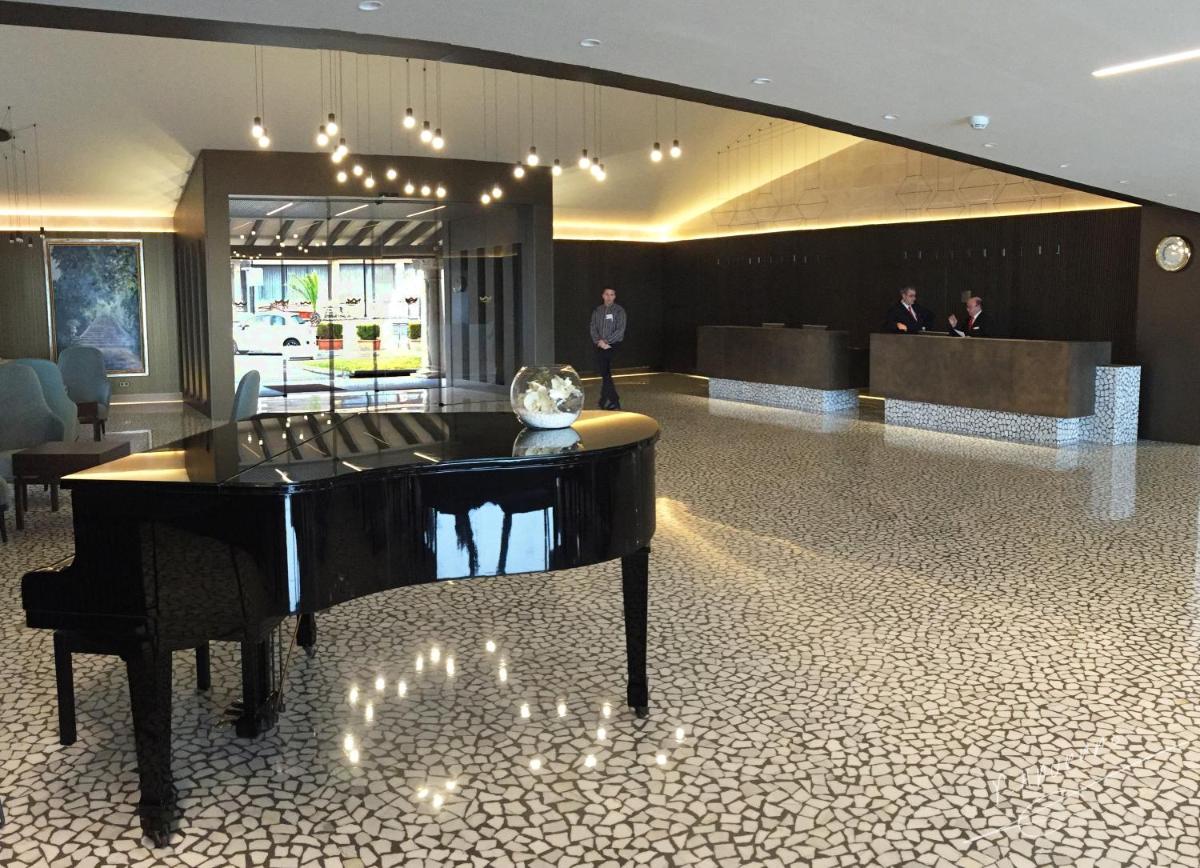 un piano de cola en un vestíbulo con gente de fondo en Palace Bonanza Playa Resort & SPA by Olivia Hotels Collection, en Illetas 132 fotos más