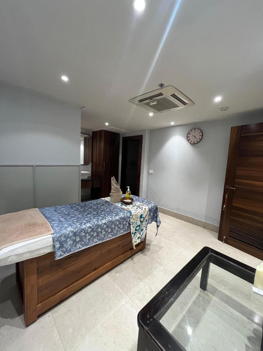 a bedroom with a bed and a clock on the wall at Regenta Dehradun by Royal Orchid Hotels Limited in Dehradun