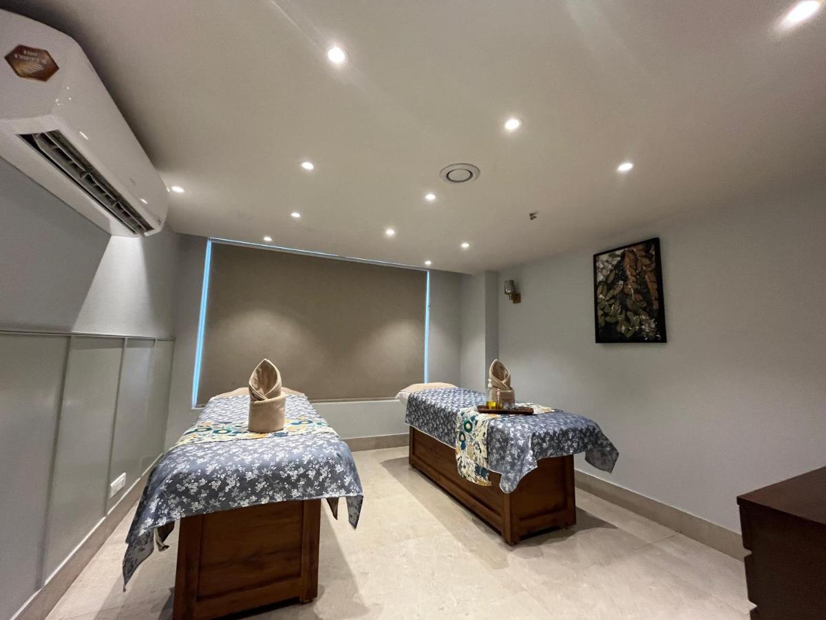 a room with two beds and a large screen at Regenta Dehradun by Royal Orchid Hotels Limited in Dehradun