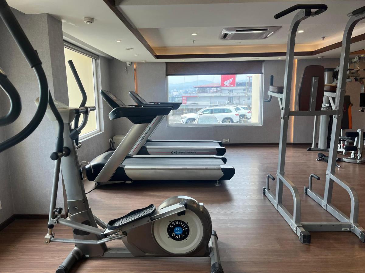 a gym with several treadmills and a treadmill at Regenta Dehradun by Royal Orchid Hotels Limited in Dehradun