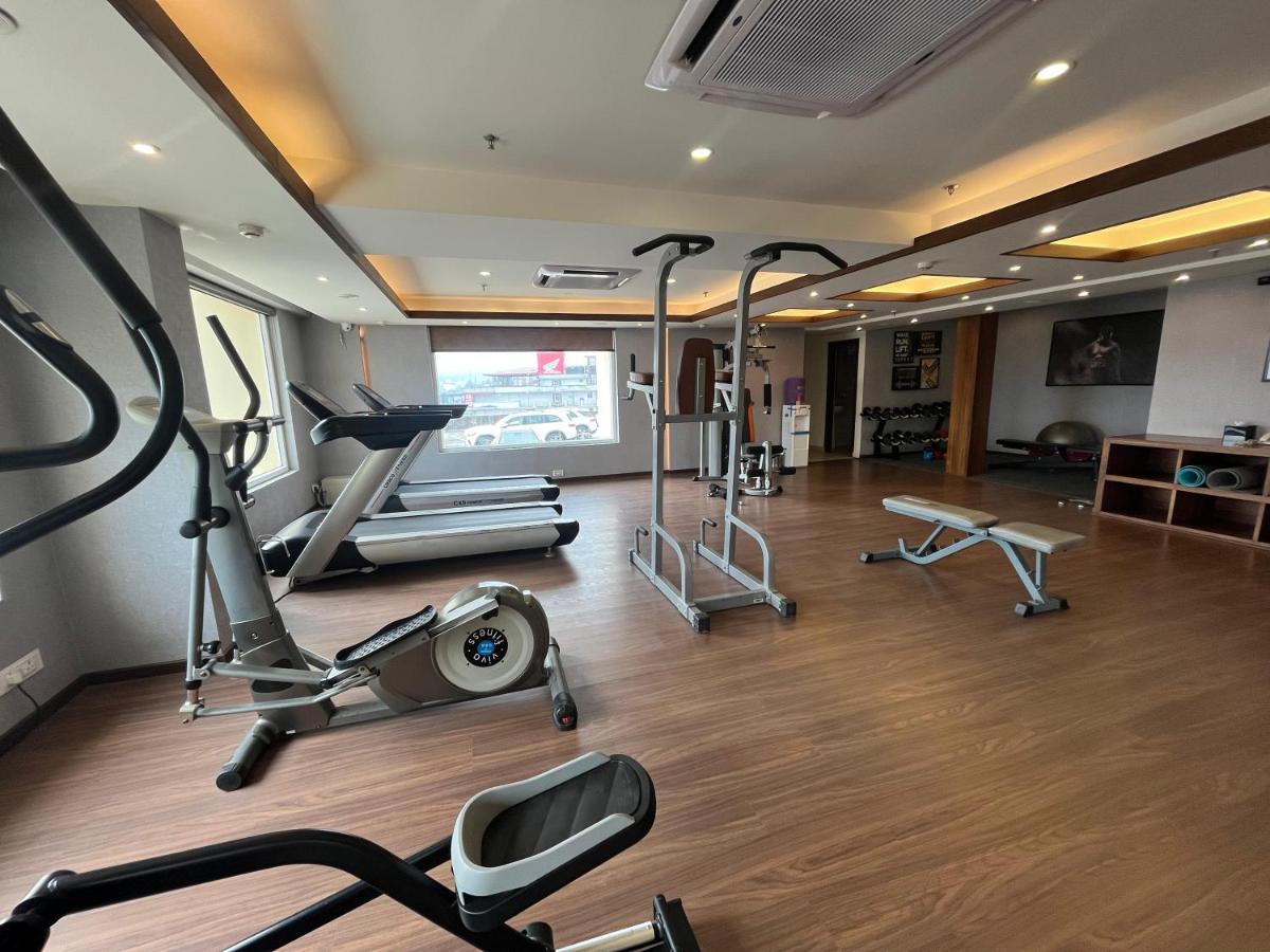 a gym with several exercise equipment in a room at Regenta Dehradun by Royal Orchid Hotels Limited in Dehradun