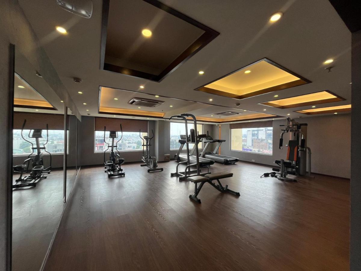 a gym with treadmills and ellipticals in a building at Regenta Dehradun by Royal Orchid Hotels Limited in Dehradun