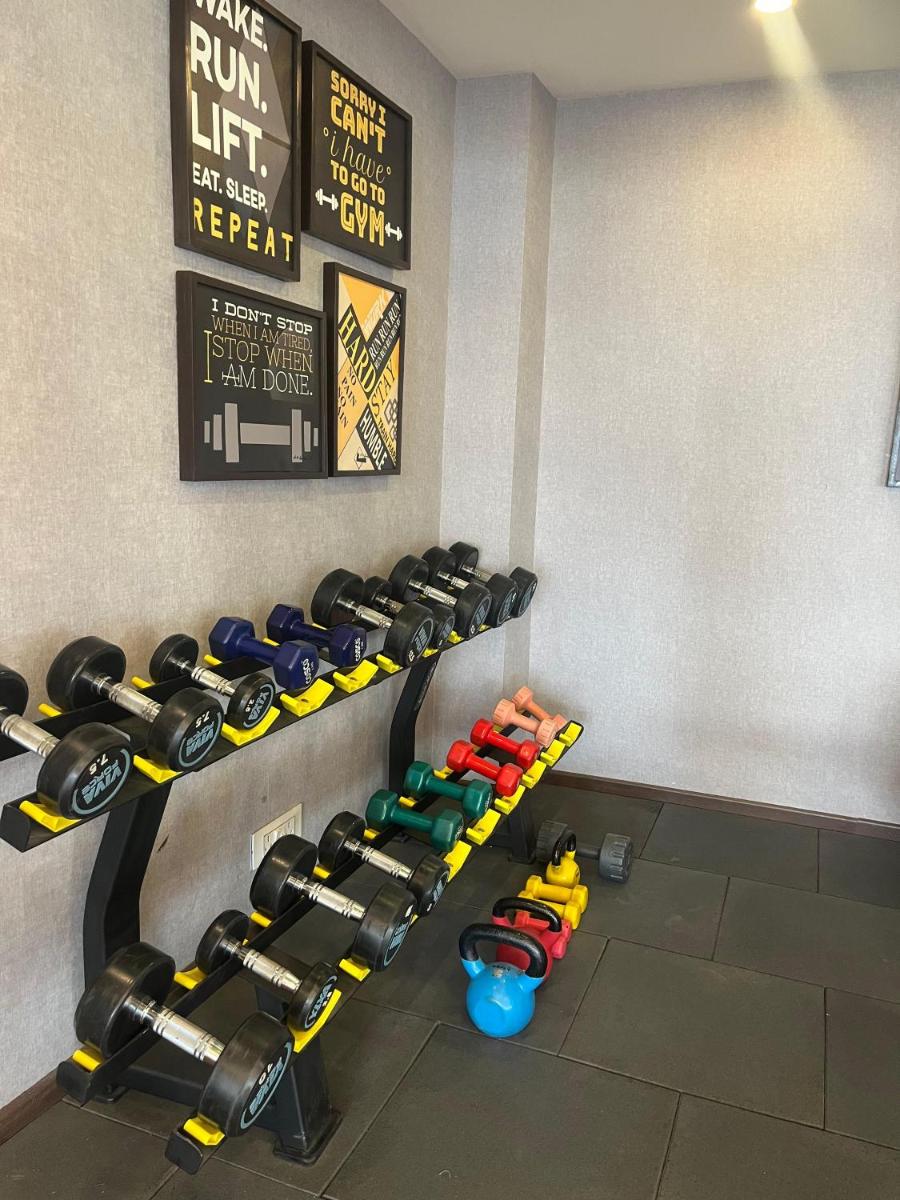 a gym with rows of dumbbells on a wall at Regenta Dehradun by Royal Orchid Hotels Limited in Dehradun