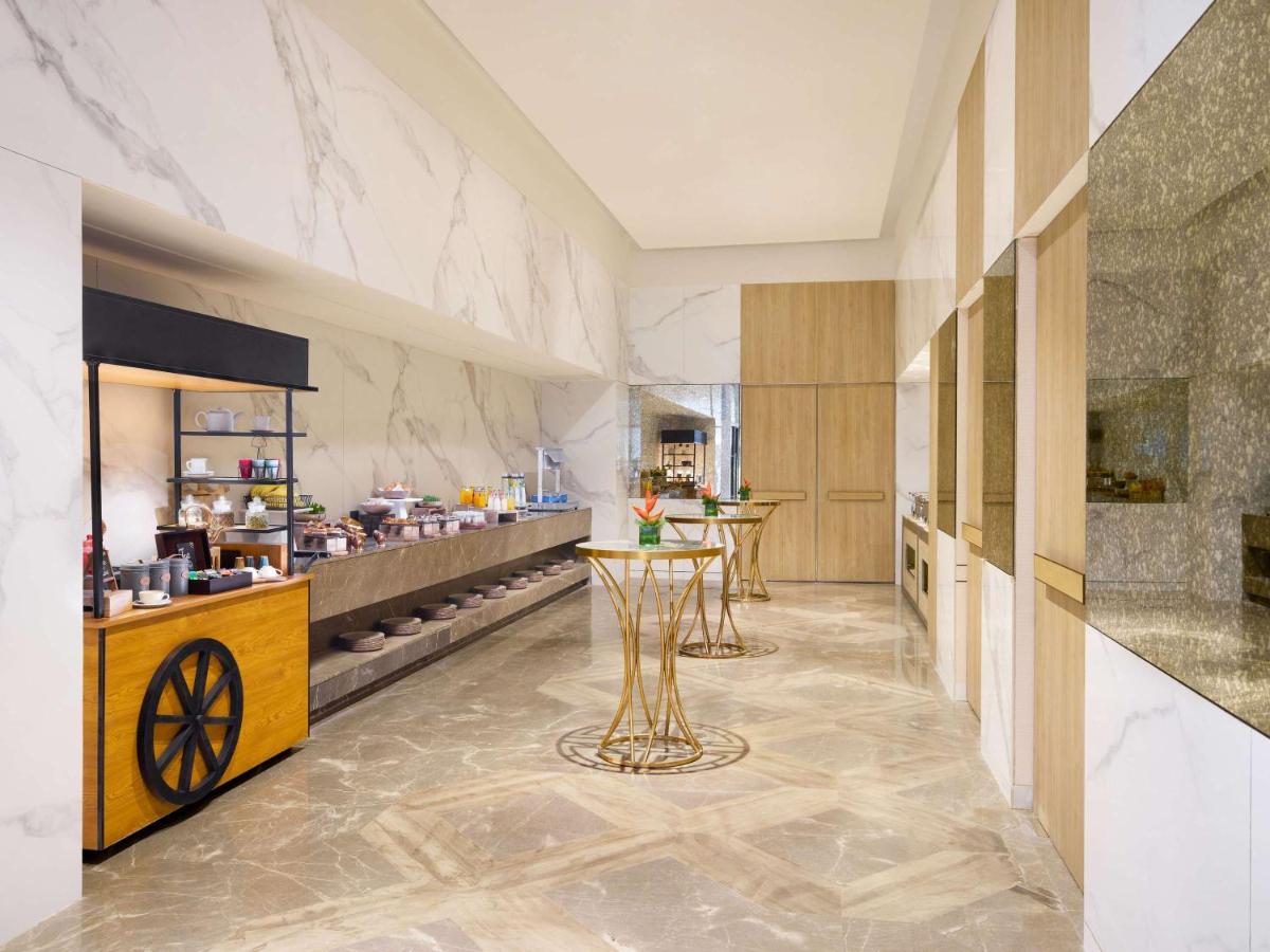 a kitchen with a table in the middle of a room at Novotel New Delhi City Centre in New Delhi a kitchen with a table in the middle of a room at Novotel New Delhi City Centre in New Delhi