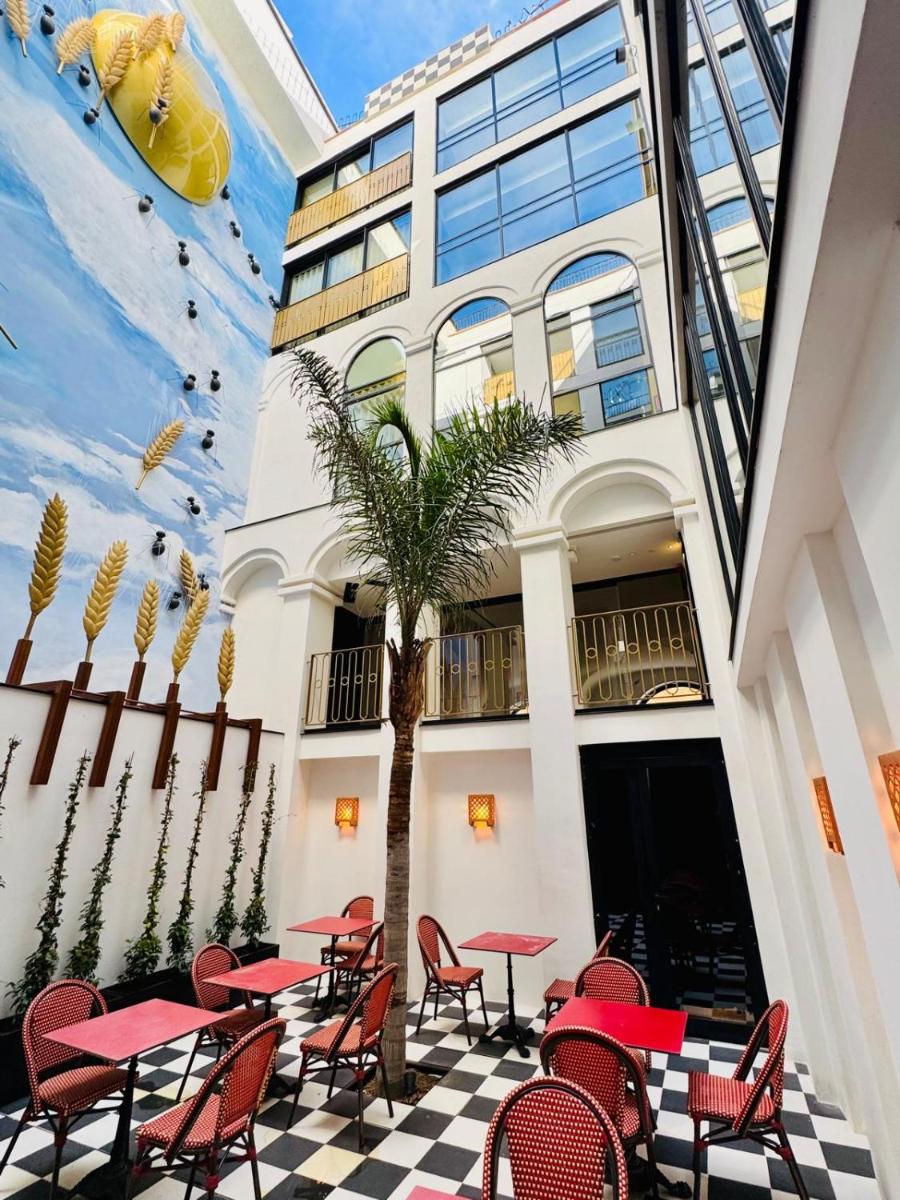 Un restaurante con mesas y sillas frente a un edificio. en Hotel Divino & Aparthotel, en Figueres Un restaurante con mesas y sillas frente a un edificio. en Hotel Divino & Aparthotel, en Figueres