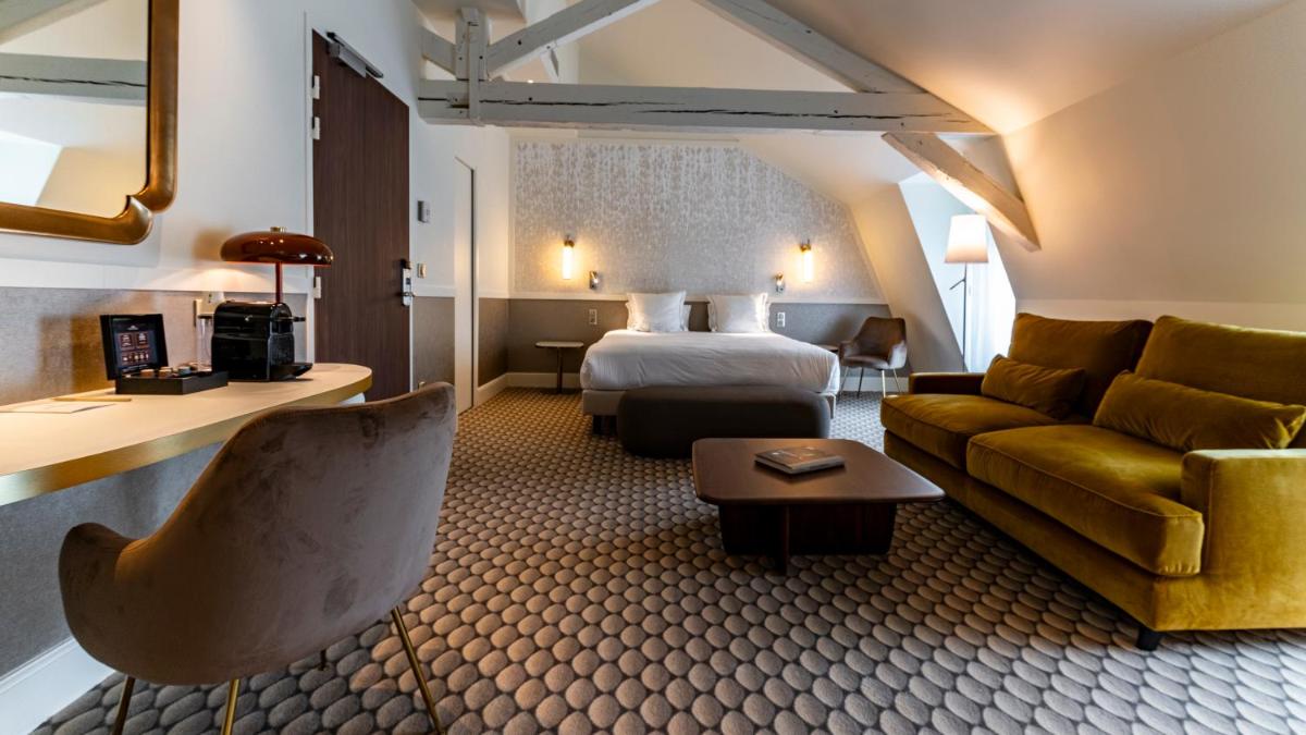 une chambre d'hôtel avec un lit et un canapé dans l'établissement Continental Hotel, à Reims