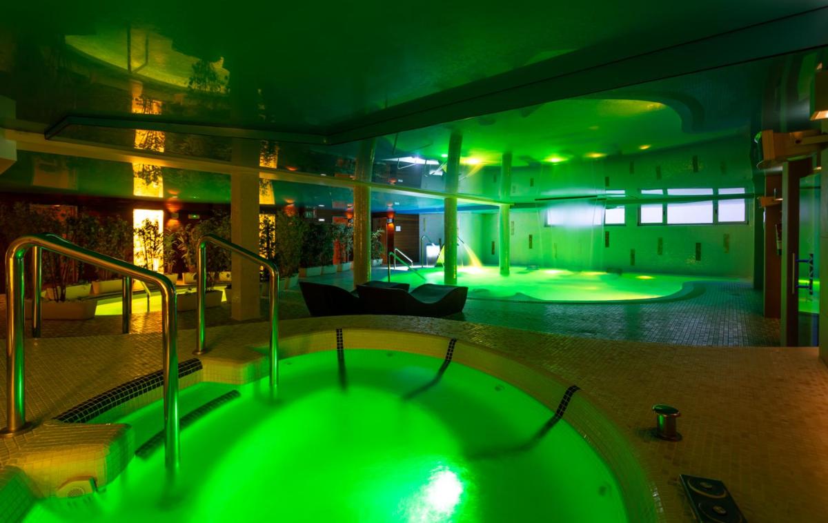 Una gran bañera verde en una habitación con sala de estar. en Hotel Felisa SPA, en Queveda