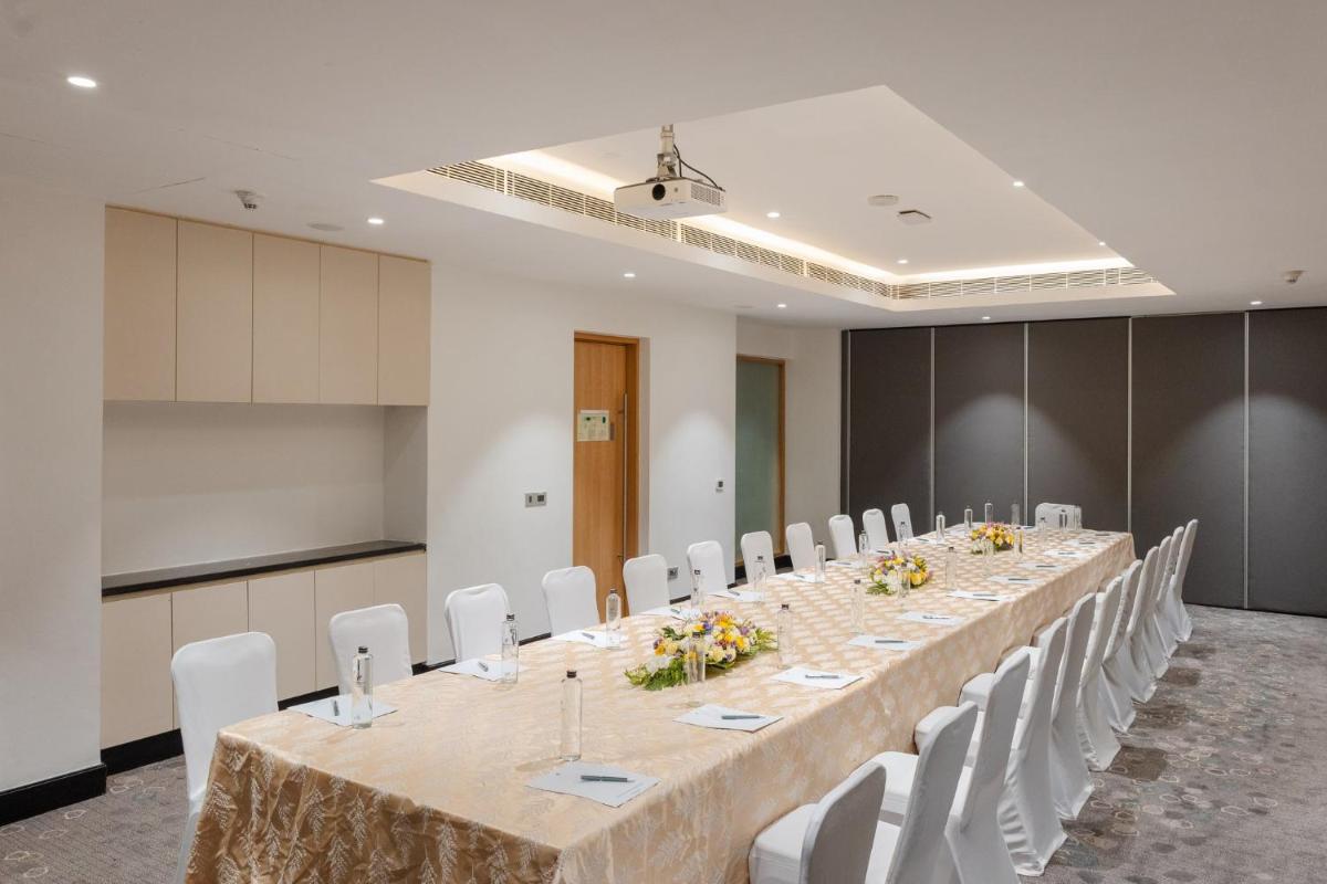 a conference room with a long table and white chairs at Holiday Inn Chennai OMR IT Expressway by IHG in Chennai
