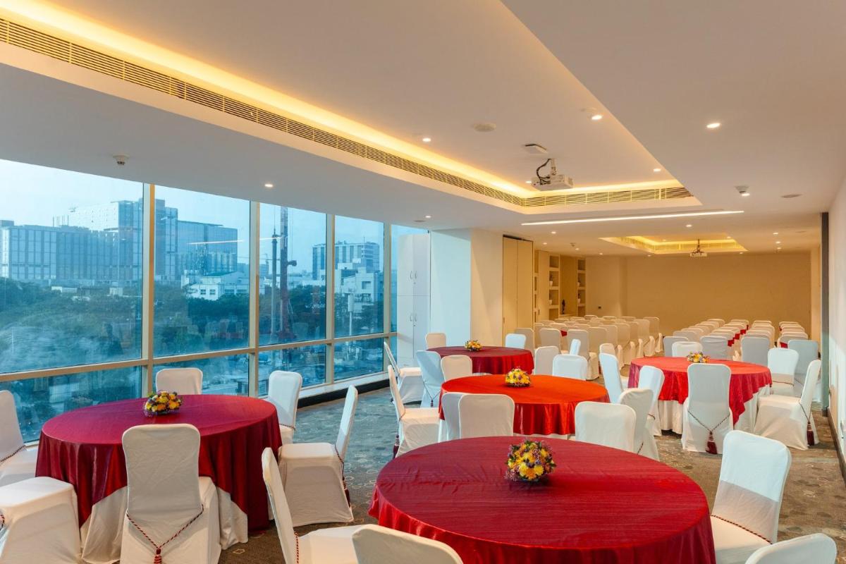 a banquet hall with red and white tables and white chairs at Holiday Inn Chennai OMR IT Expressway by IHG in Chennai