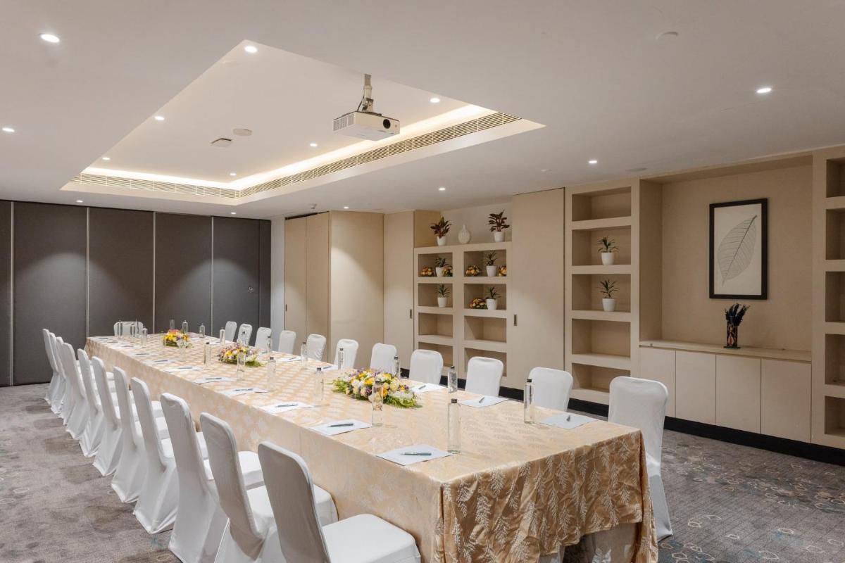 a conference room with a long table and white chairs at Holiday Inn Chennai OMR IT Expressway by IHG in Chennai