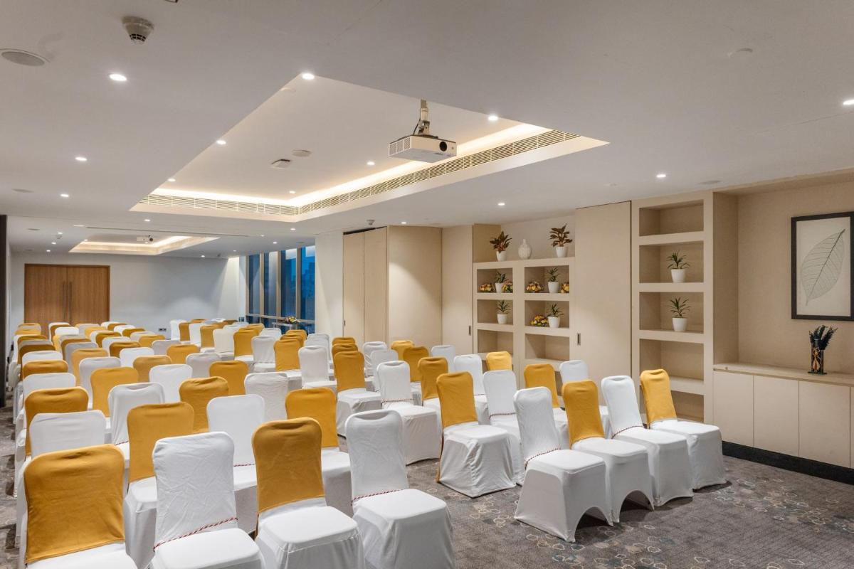 an empty room with white and yellow chairs at Holiday Inn Chennai OMR IT Expressway by IHG in Chennai
