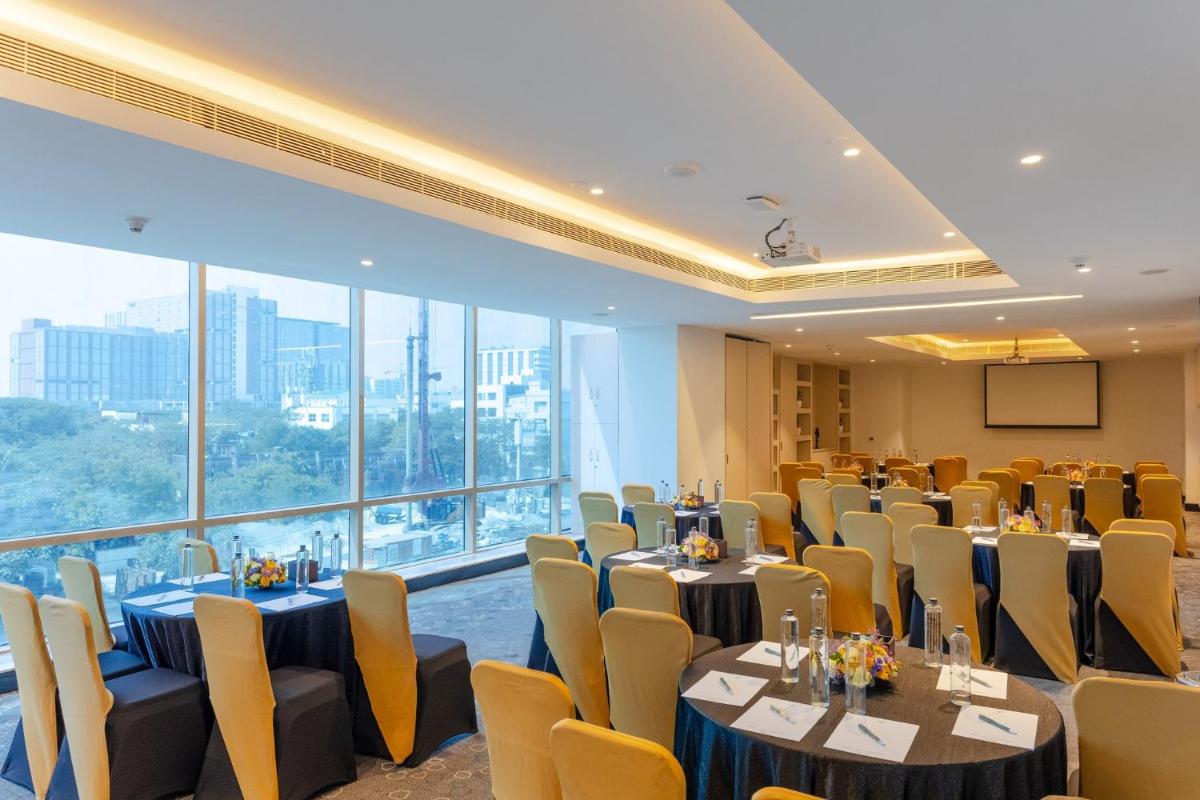 a conference room with tables and chairs and a large window at Holiday Inn Chennai OMR IT Expressway by IHG in Chennai +127 photos