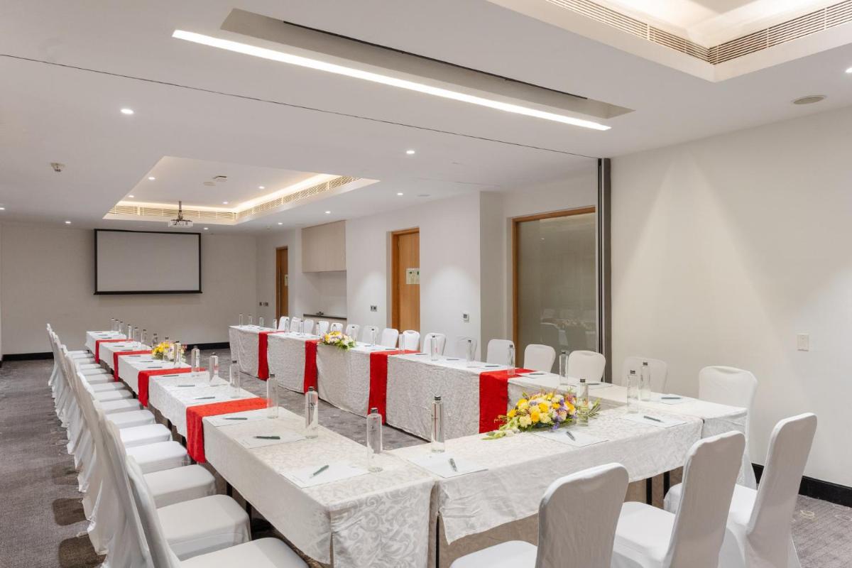 a conference room with white tables and white chairs at Holiday Inn Chennai OMR IT Expressway by IHG in Chennai