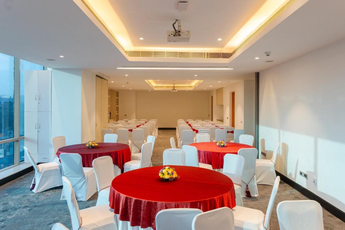 a conference room with red tables and white chairs at Holiday Inn Chennai OMR IT Expressway by IHG in Chennai