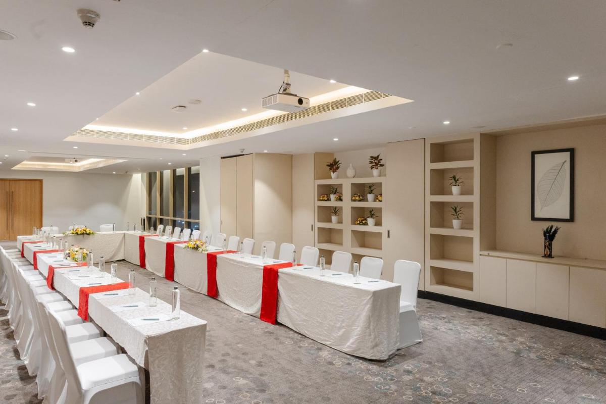 a banquet hall with white tables and white chairs at Holiday Inn Chennai OMR IT Expressway by IHG in Chennai