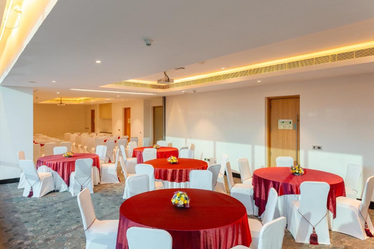 a banquet hall with red and white tables and white chairs at Holiday Inn Chennai OMR IT Expressway by IHG in Chennai