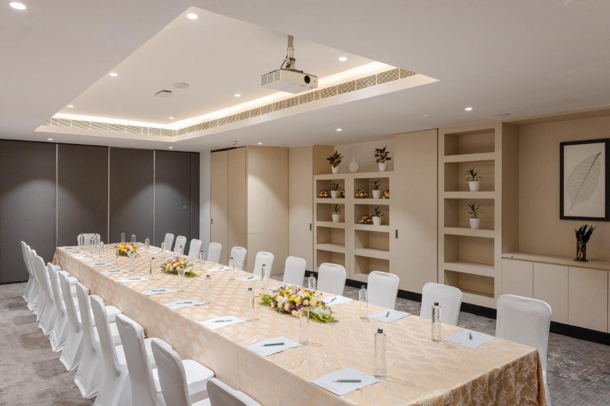 a conference room with a long table and white chairs at Holiday Inn Chennai OMR IT Expressway by IHG in Chennai