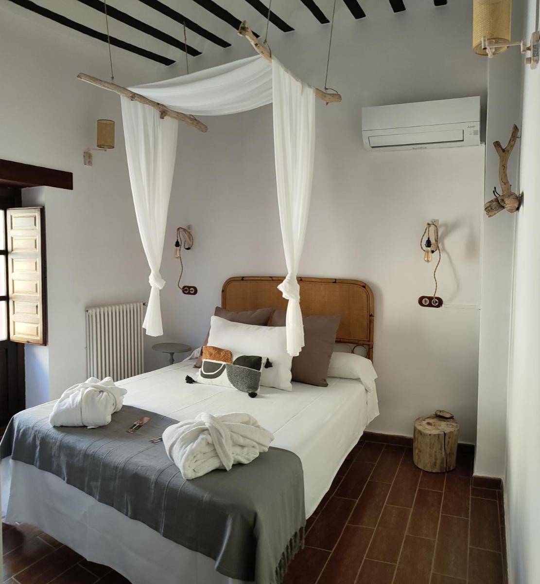 Un dormitorio con una cama con dos toallas encima. en Hotel La Casa del Canónigo, en Caracenilla