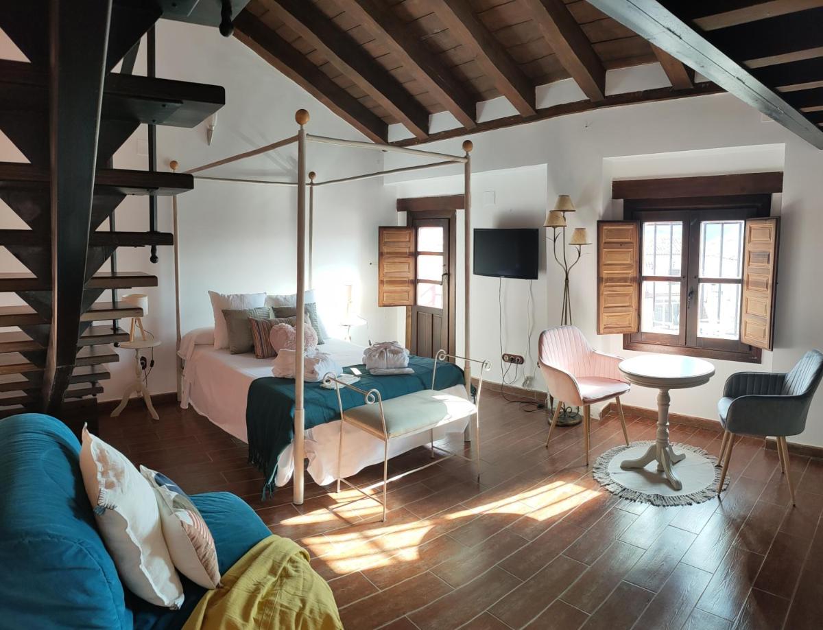 sala de estar con cama y mesa en una habitación en Hotel La Casa del Canónigo, en Caracenilla