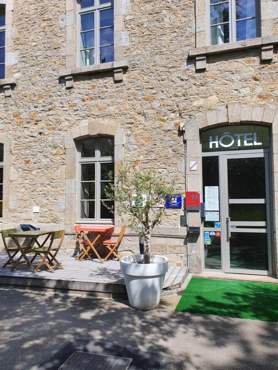 un bâtiment d'hôtel avec une table et un arbre devant lui dans l'établissement Brit Hotel Spa Le Connetable, à Dinan