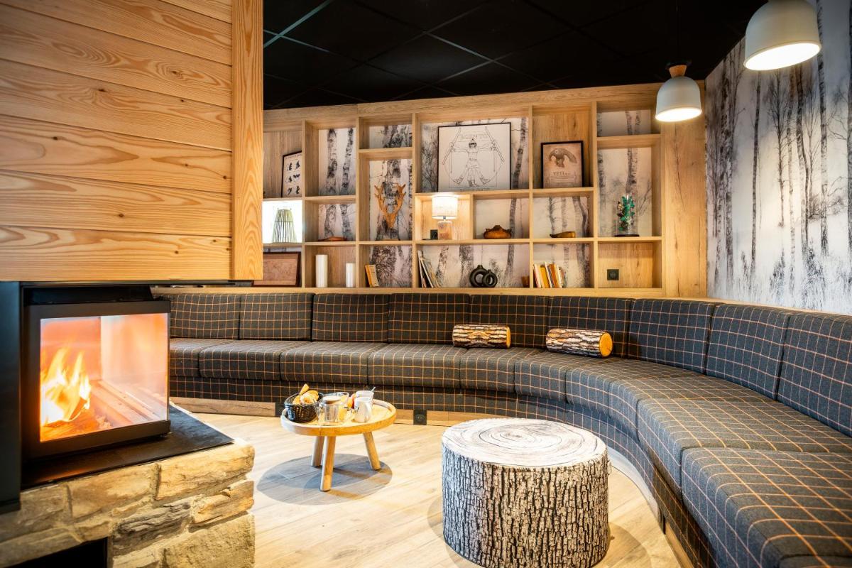 un salon avec une cheminée et un canapé dans l'établissement Résidence Club MMV Le Silvana, à Risoul