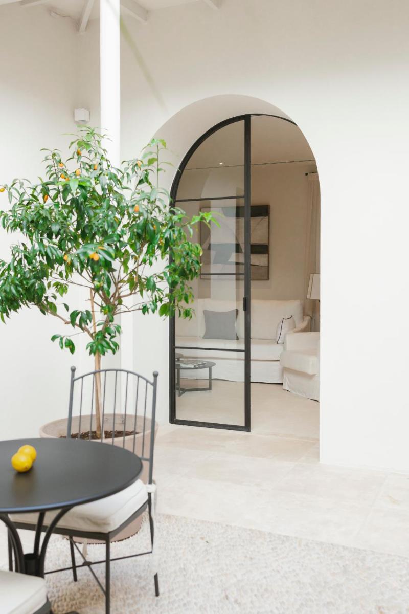 Un comedor con una mesa y un espejo. en Hotel Boutique Sidonia, en Jerez de la Frontera