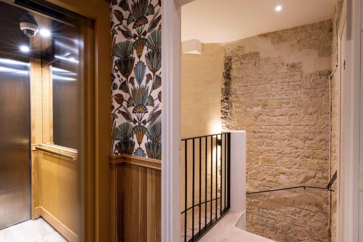 un couloir avec une porte et un mur en briques dans l'établissement Madame Drouot & Spa - Opera, à Paris