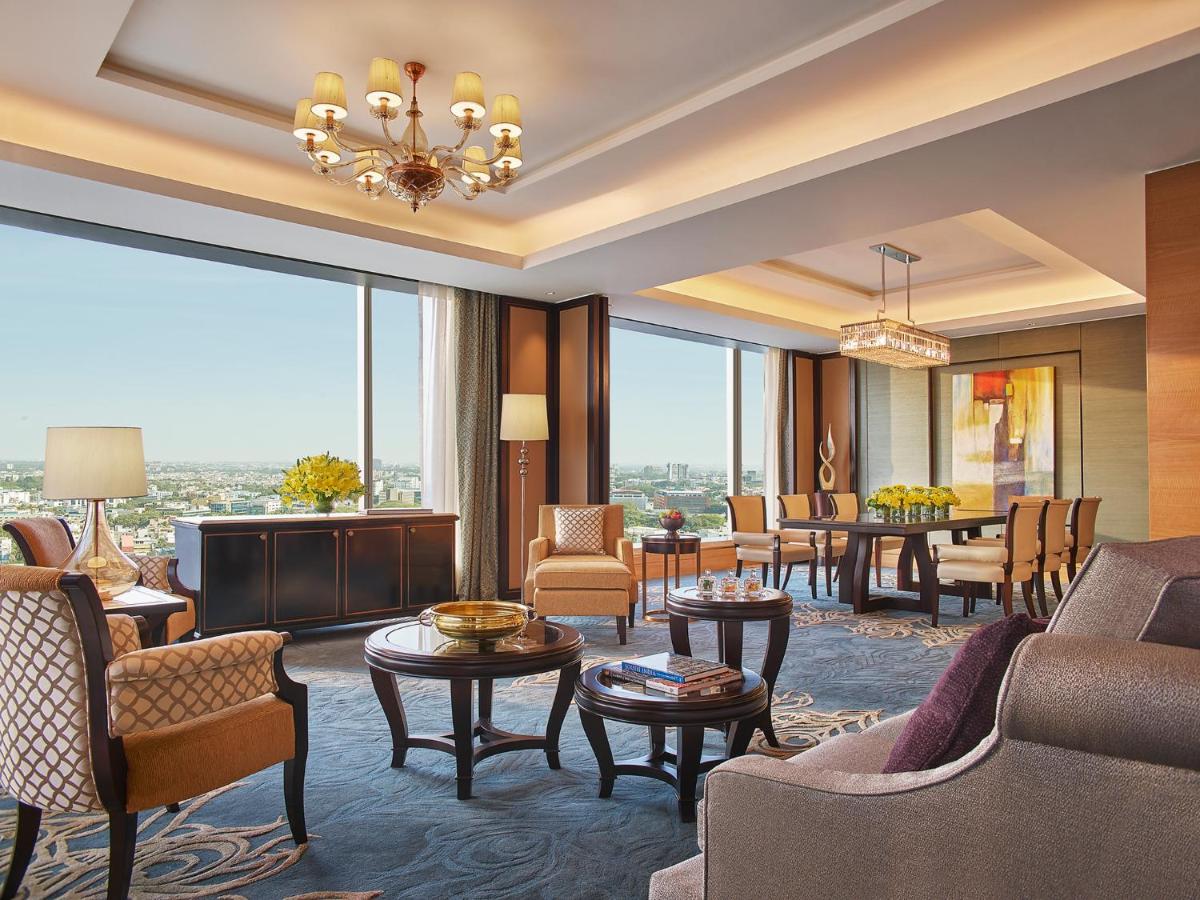 a living room with furniture and a large window at Shangri-La Bengaluru in Bengaluru a living room with furniture and a large window at Shangri-La Bengaluru in Bengaluru