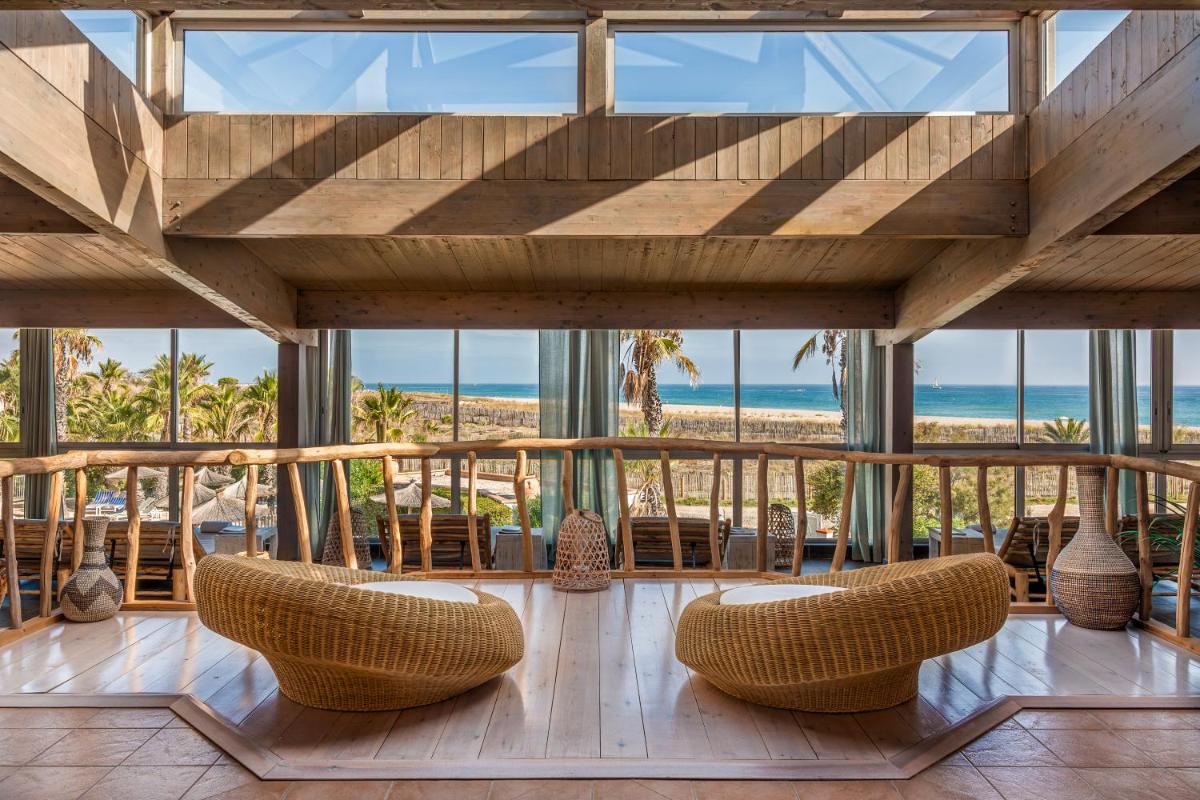 - une chambre avec vue sur la plage et des chaises dans l'établissement Les Bulles de Mer - Hotel & Spa sur la Plage, à Saint-Cyprien