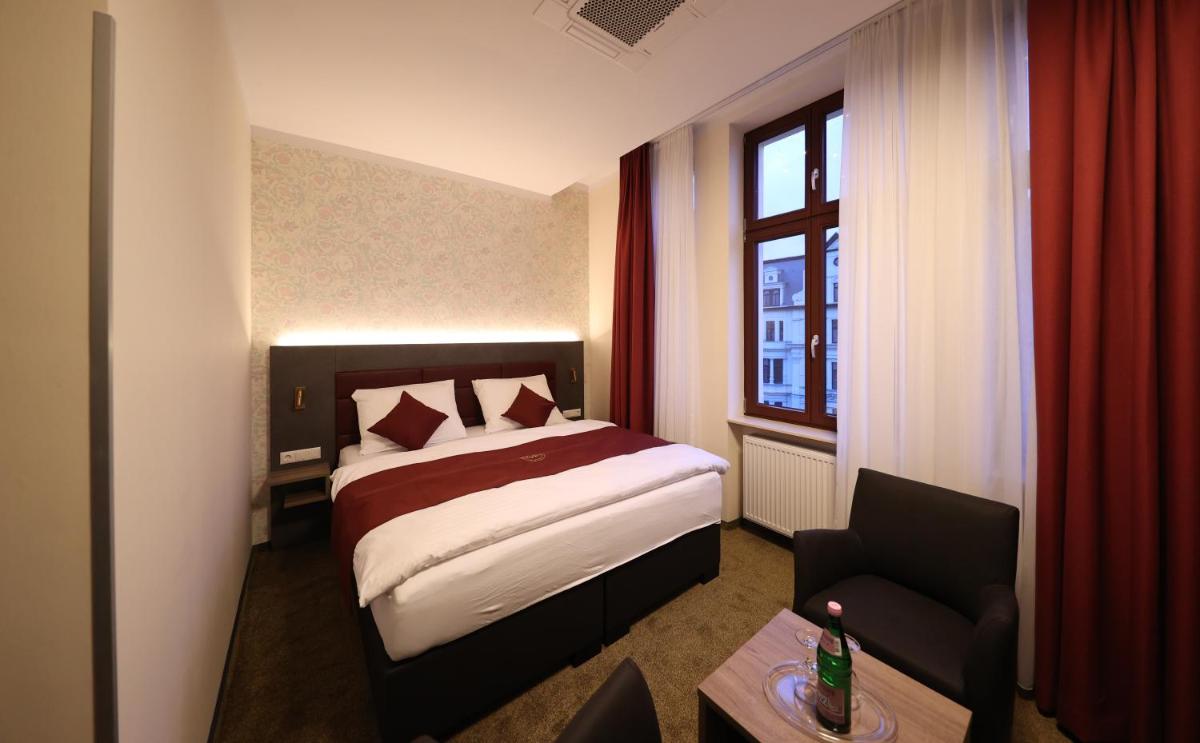 ein Hotelzimmer mit einem Bett und einem Fenster in der Unterkunft Hotel Golden Pearl Magdeburg im Stadtzentrum in Magdeburg