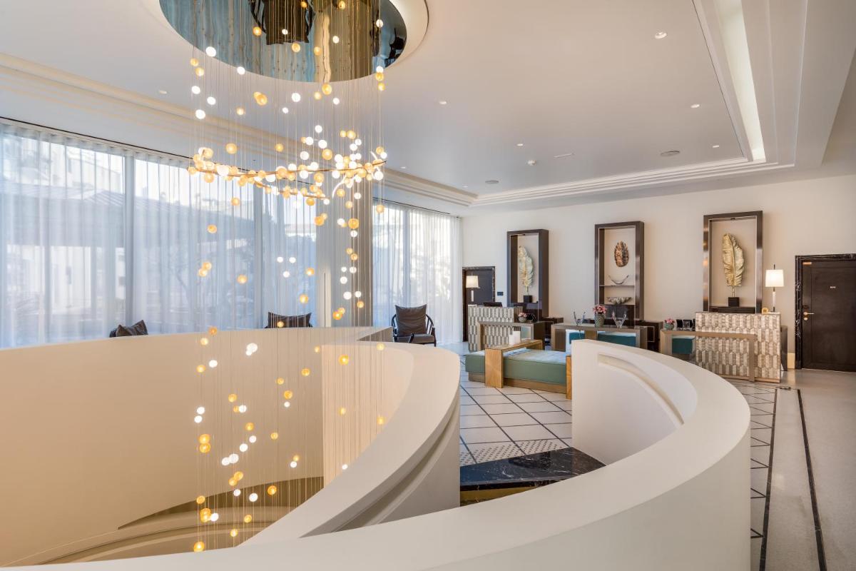 un hall avec un lustre et un salon dans l'établissement Maison Albar - Le Victoria, à Nice