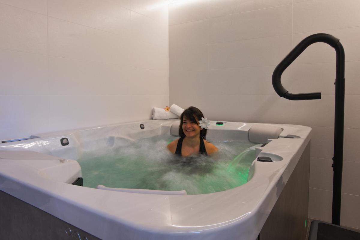 une femme dans une baignoire avec de l'eau verte dans l'établissement The Originals City, Ara Hôtel, Landerneau, à Landerneau 70 autres photos