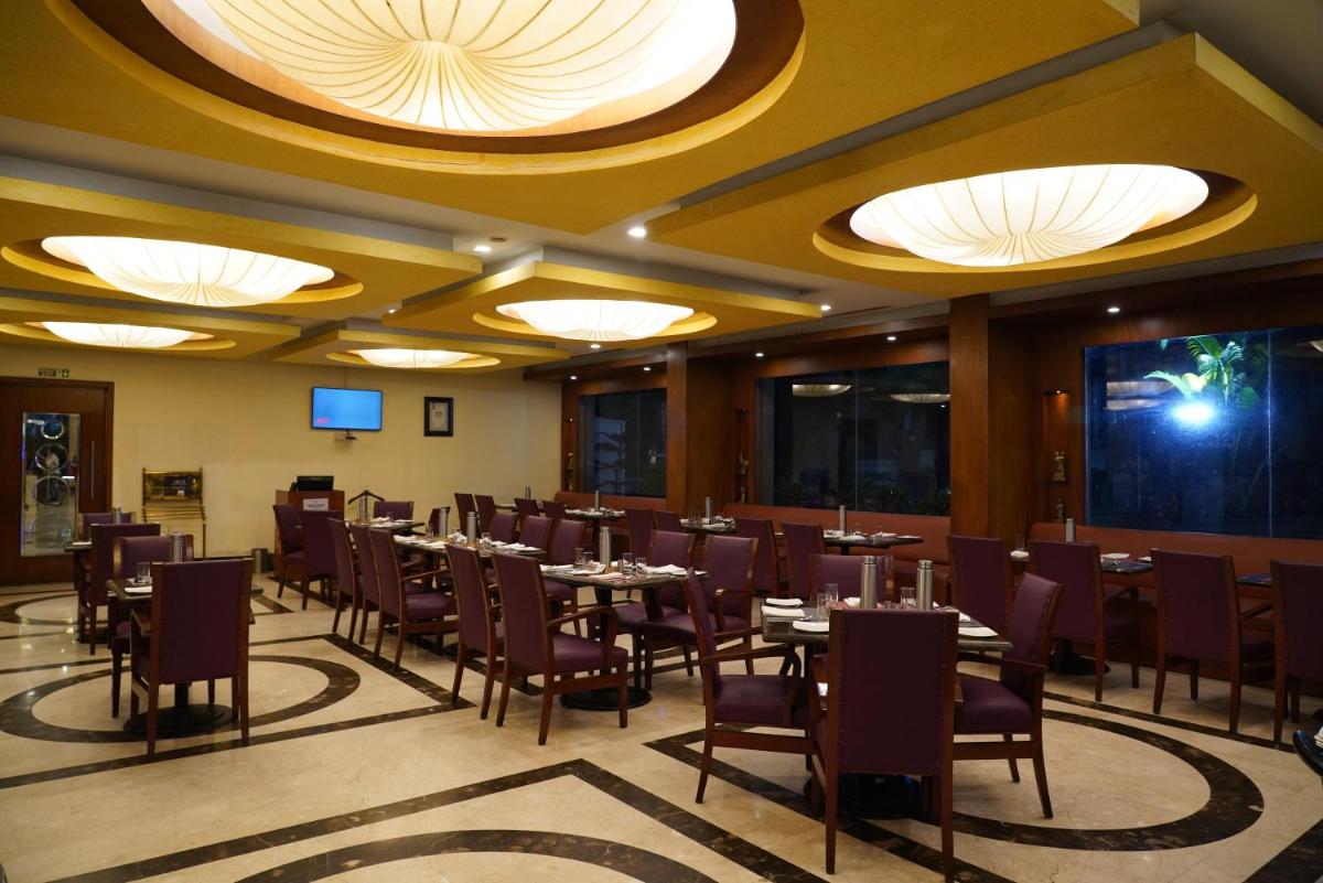 a dining room with tables and chairs and lights at Fortune Select JP Cosmos, Bengaluru - Member ITC Hotels' Group in Bengaluru