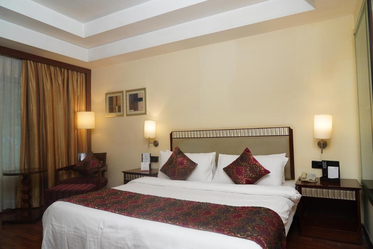 a hotel room with a large bed with red pillows at Fortune Select JP Cosmos, Bengaluru - Member ITC Hotels' Group in Bengaluru