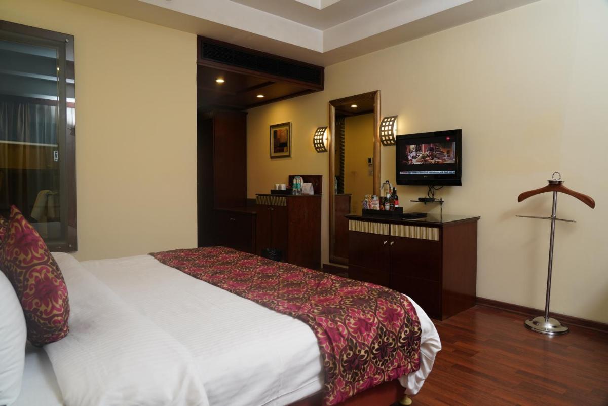 a hotel room with a bed and a television at Fortune Select JP Cosmos, Bengaluru - Member ITC Hotels' Group in Bengaluru