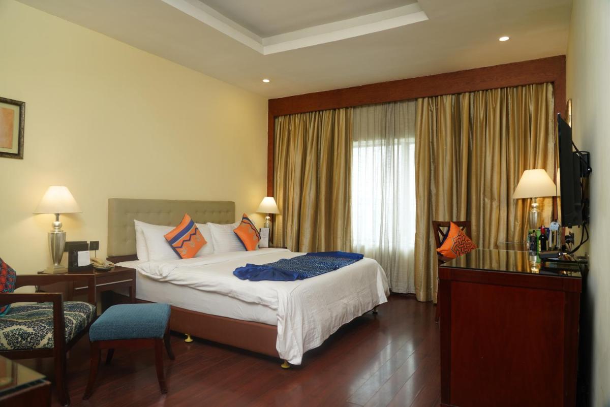 a hotel room with a large bed and a desk at Fortune Select JP Cosmos, Bengaluru - Member ITC Hotels' Group in Bengaluru