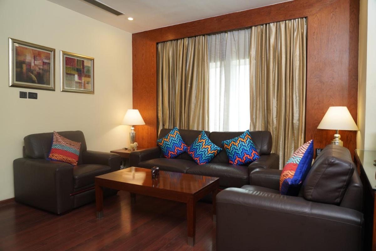 a living room with a leather couch and a table at Fortune Select JP Cosmos, Bengaluru - Member ITC Hotels' Group in Bengaluru