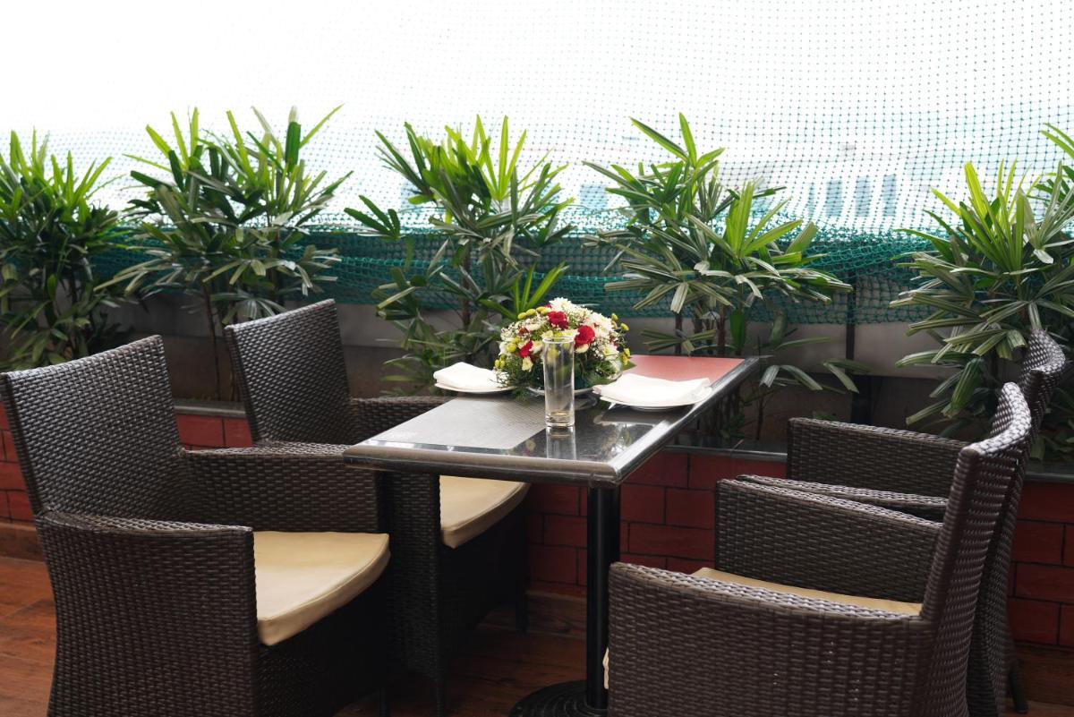 a table with chairs and a vase of flowers on it at Fortune Select JP Cosmos, Bengaluru - Member ITC Hotels' Group in Bengaluru