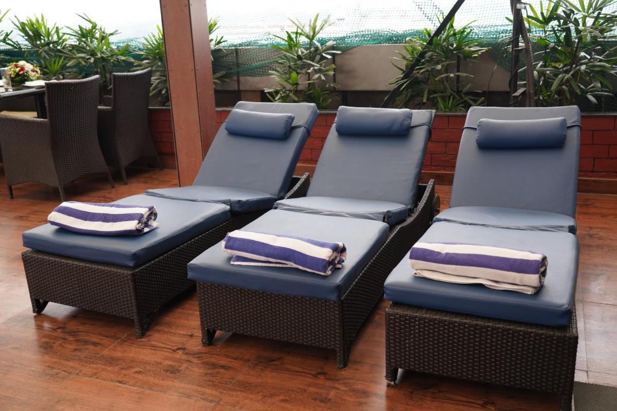 three chairs with pillows on them in a restaurant at Fortune Select JP Cosmos, Bengaluru - Member ITC Hotels' Group in Bengaluru