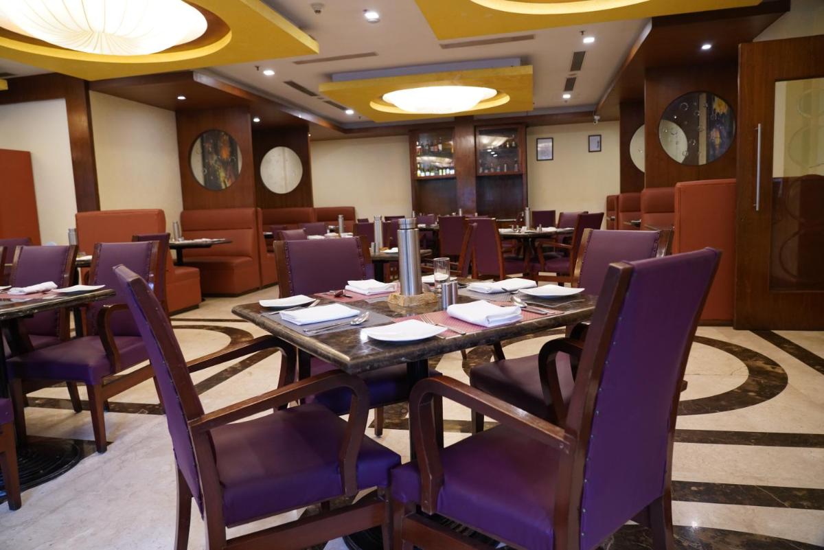 a dining room with a long table and purple chairs at Fortune Select JP Cosmos, Bengaluru - Member ITC Hotels' Group in Bengaluru