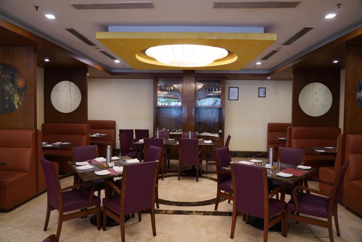 a restaurant with tables and chairs and a chandelier at Fortune Select JP Cosmos, Bengaluru - Member ITC Hotels' Group in Bengaluru