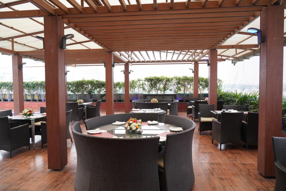 a dining room with tables and chairs and a wooden ceiling at Fortune Select JP Cosmos, Bengaluru - Member ITC Hotels' Group in Bengaluru
