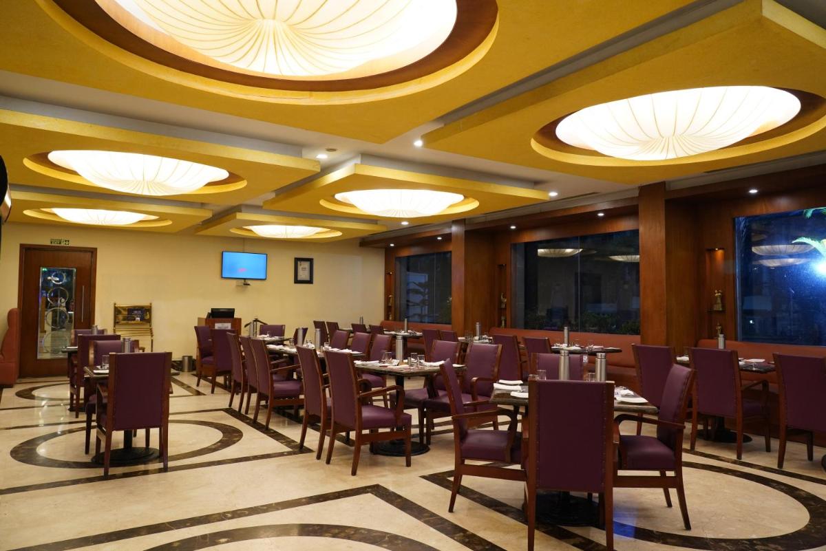 a dining room with tables and chairs and lights at Fortune Select JP Cosmos, Bengaluru - Member ITC Hotels' Group in Bengaluru